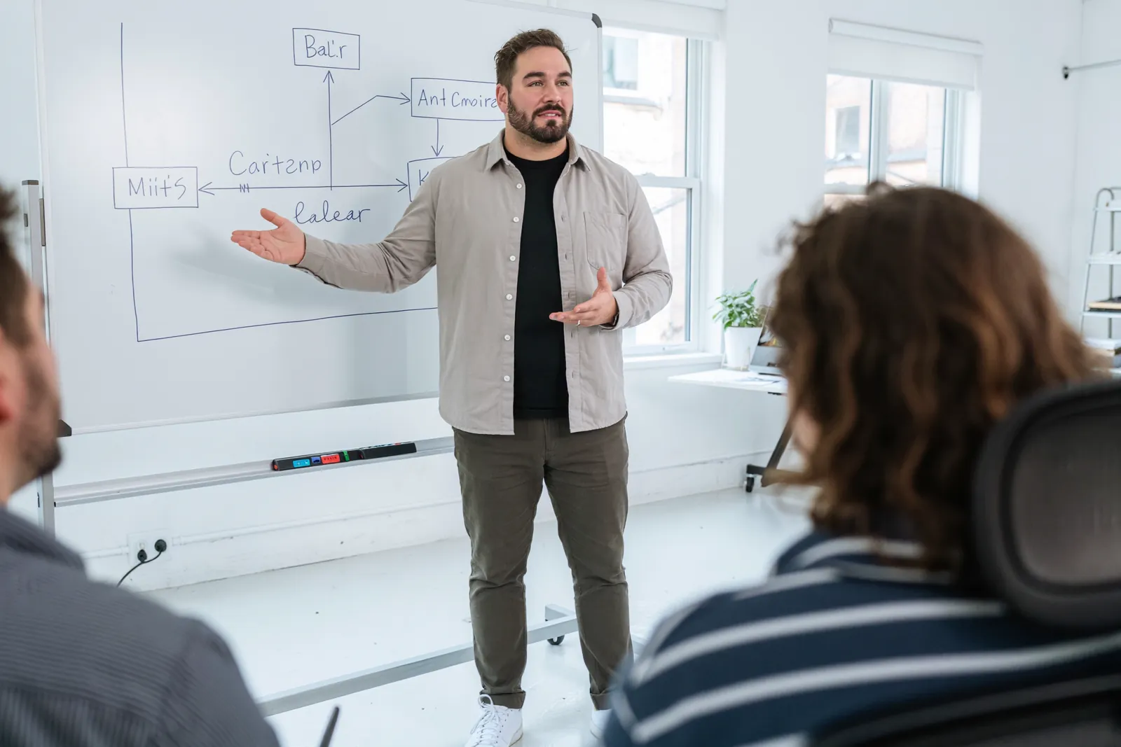 Ivo Schönberner, as fractional CTO, sketches a system diagram on a whiteboard for two founders